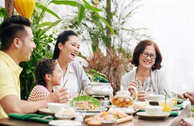 Happy,Family,Eating,And,Talking,At,Family,Dinner,When,Celebrating